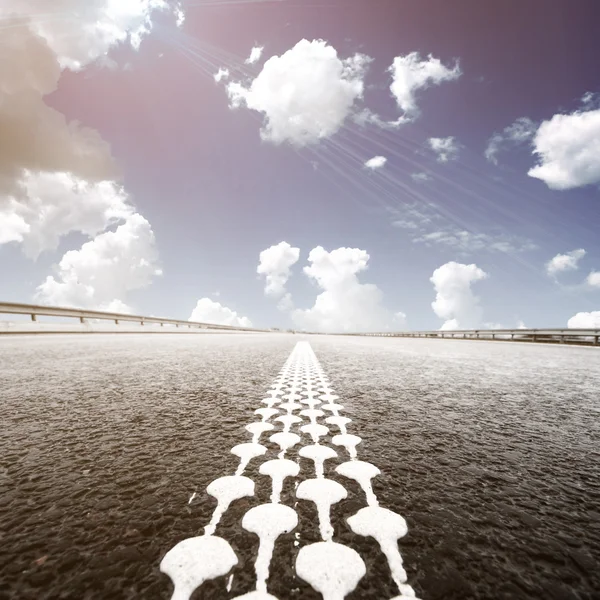 Asphalt road to horizon with cloudy sky — Stock Photo, Image