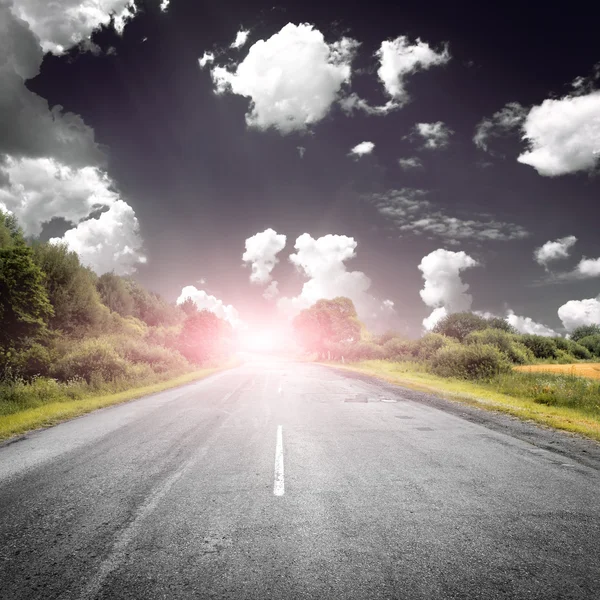 Asphaltstraße in der Nähe von grünen Feldern — Stockfoto