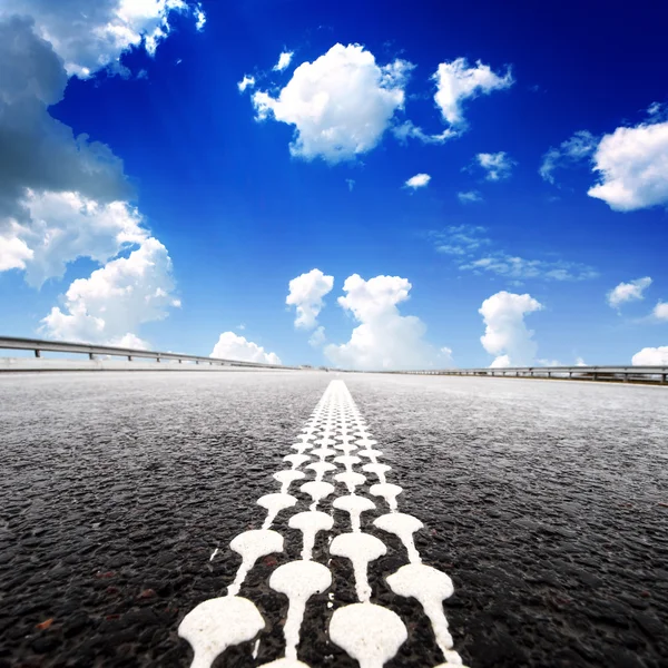 Asfalto camino al horizonte con cielo nublado — Foto de Stock