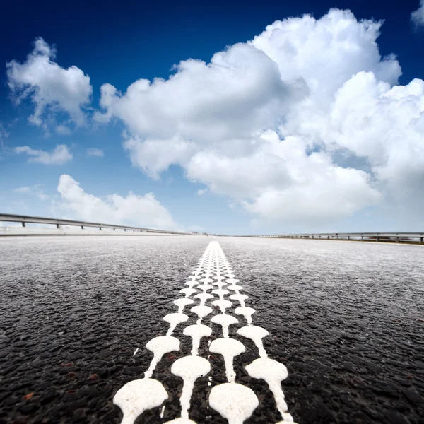 Strada asfaltata all'orizzonte con cielo nuvoloso — Foto Stock