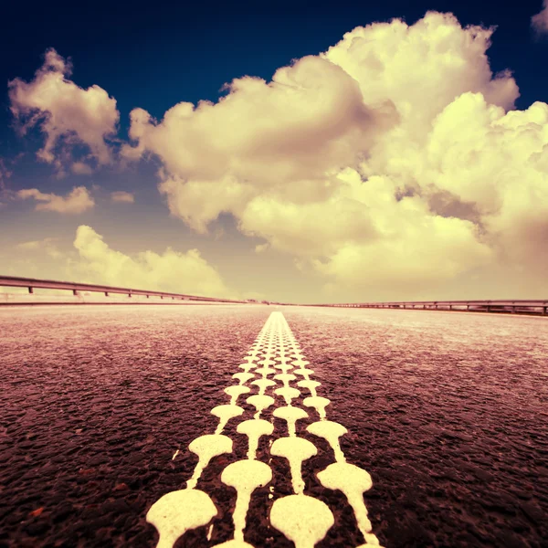 Strada asfaltata all'orizzonte con cielo nuvoloso — Foto Stock