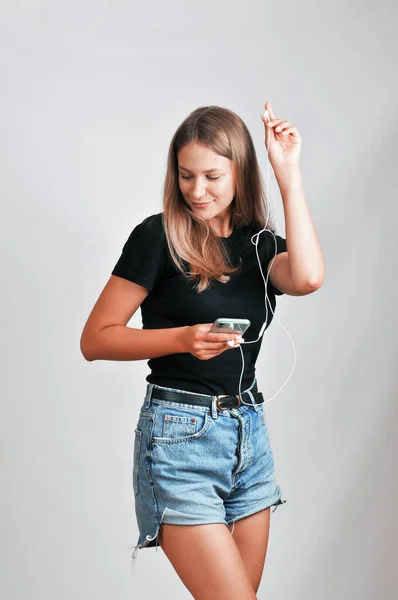 Portrait Cheerful Young Woman Wearing Black Shirt Jeans Shorts Listening — Stok fotoğraf