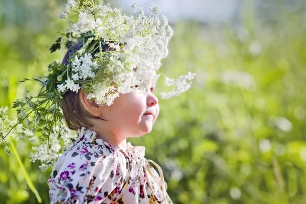 Porträtt av liten flicka i ett fält av blommor — Stockfoto