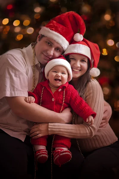 In Kerstmis hoeden en gelukkige familie — Stockfoto
