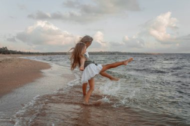 Yaz akşamları deniz kıyısında oynayan iki kız kardeş.