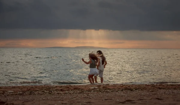 Dvě Sestry Létě Večer Hrají Břehu Moře — Stock fotografie