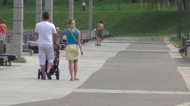 genç ailesi ile boyunca strolling bebek arabası