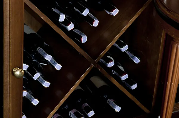 Stacked wine bottles on wooden racks — Stock Photo, Image