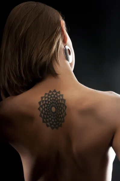 Beautiful woman with tattoo on her back — Stock Photo, Image