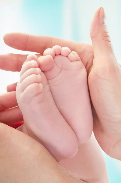 Madre sosteniendo los pies de su hijo — Foto de Stock