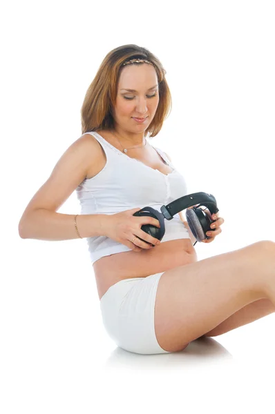 Pregnant woman with headphones on her stomach — Stock Photo, Image