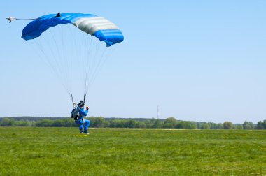 BORODIANKA, KIEV- MAY 2, 2012: parachutist lands on the airfield from an airplane L-410, on May 2, 2012, Borodianka, Ukraine clipart