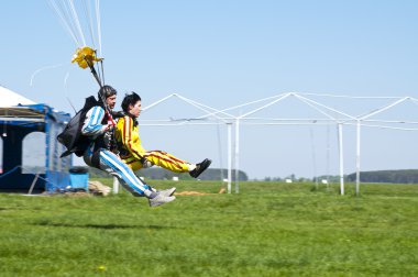 BORODIANKA, KIEV- MAY 2, 2012: skydiving tandem lands on the grass from an airplane L-410, on May 2, 2012, Borodianka, Ukraine clipart