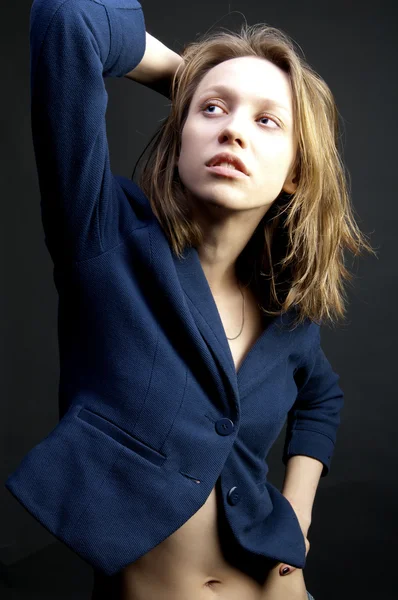 暗い背景に青のジャケットにきれいな女性 — ストック写真