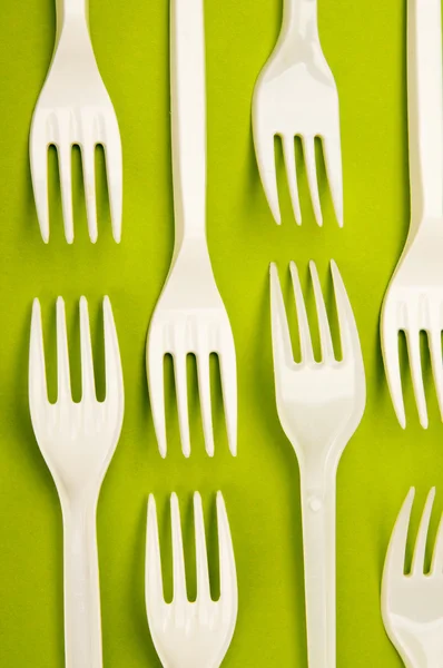 在绿色背景上的塑料叉子 — 图库照片