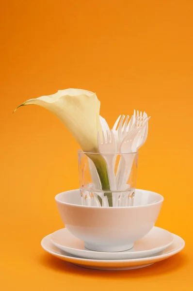 Placas, xícara, vidro com garfos e flor — Fotografia de Stock