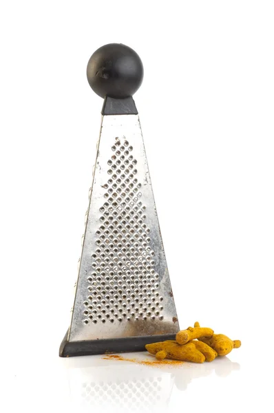 Turmeric root with steel hand grater — Stock Photo, Image