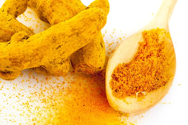 Cuillère avec poudre de curcuma et écorces de curcuma — Photo