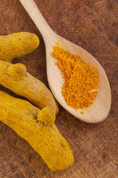 Spoon with turmeric powder and barks of turmeric — Stock Photo, Image