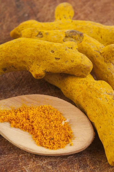 Cucchiaio con curcuma in polvere e cortecce di curcuma — Foto Stock