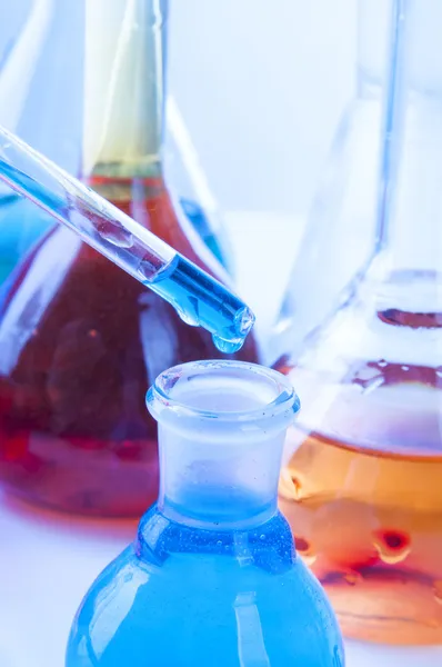 Blue reagent drop into the glass flask — Stock Photo, Image