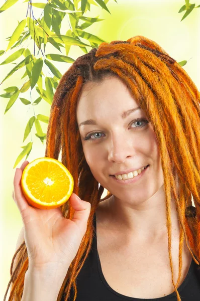 Beautiful girl with red dreadlocks holding orange — Stock Photo, Image