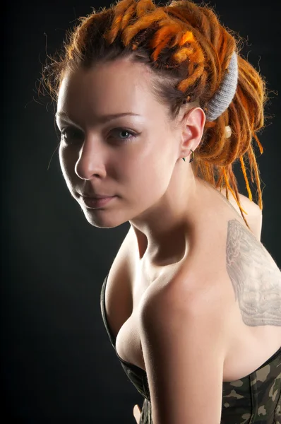 Beautiful girl with red dreadlocks posing in military corset — Stock Photo, Image