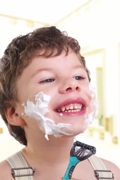 Улыбающийся ребенок бреется — стоковое фото