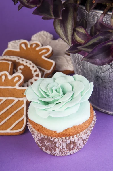 Koekjes en cupcake met groene roos — Stockfoto