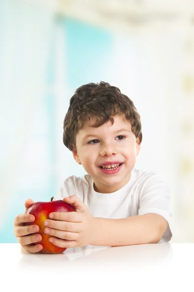 Улыбающийся мальчик с красным яблоком — стоковое фото
