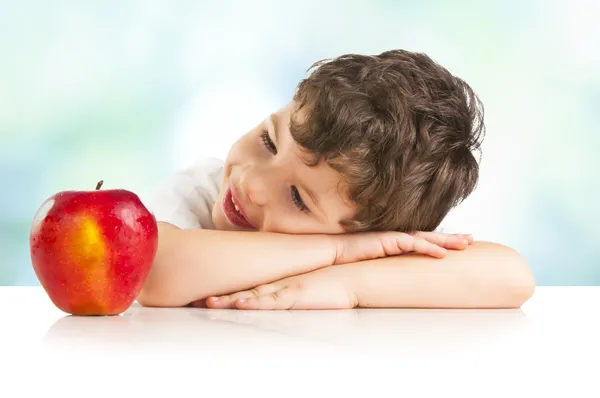 Ładny chłopczyk patrząc na czerwone jabłko — Zdjęcie stockowe