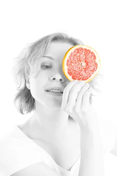 Mulher com a fatia de toranja na frente do olho — Fotografia de Stock