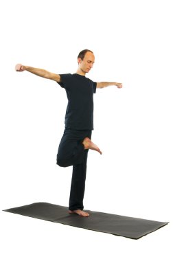 uzun boylu adam vrikshasana yoga pozisyon yapıyor
