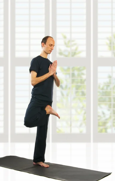 Uomo alto in posizione Vrikshasana — Foto Stock