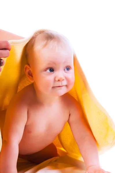 Beautiful baby girl under yellow towel — Stock Photo, Image