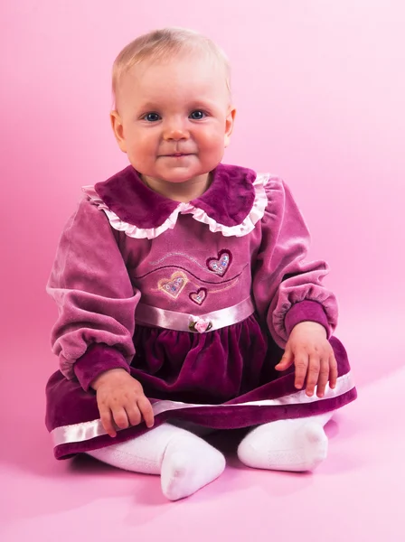 Babymeisje in paarse jurk — Stockfoto