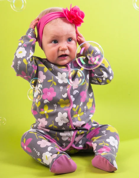 Baby girl with pink capitium and soap bubble — Stock Photo, Image