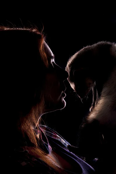 Red haired woman with ferret in the dark — Stock Photo, Image