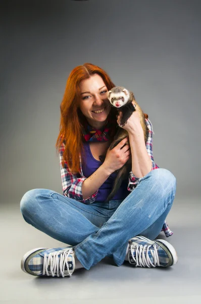 Vrouw zittend op de vloer met ferret — Stockfoto