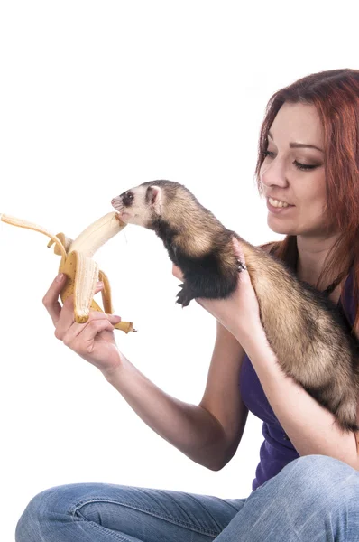 Mulher ruiva alimentando furão uma banana — Fotografia de Stock