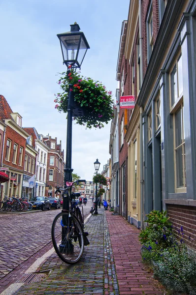 Cykel nära lyktstolpe på lange smeestraat — Stockfoto