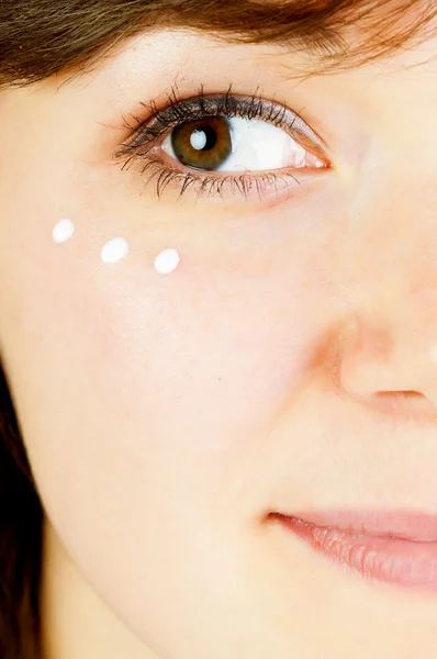 Rosto da mulher com creme facial — Fotografia de Stock