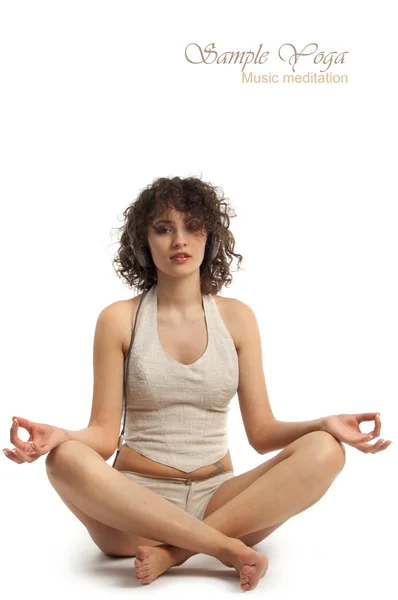 Vacker kvinna mediterar med musik i lätt yogaställning — Stockfoto