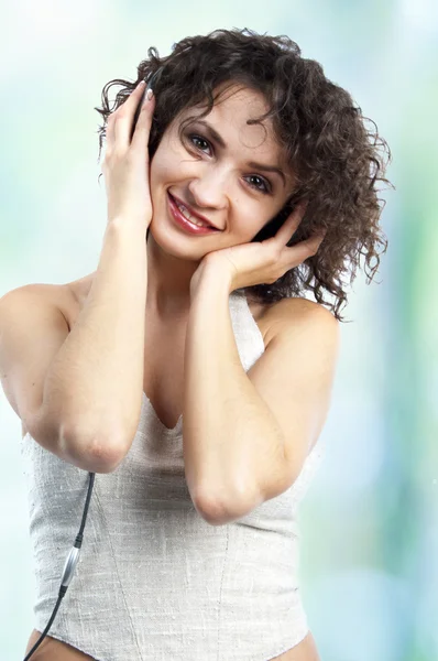 Femme mignonne avec des cheveux bouclés écoutant de la musique — Photo