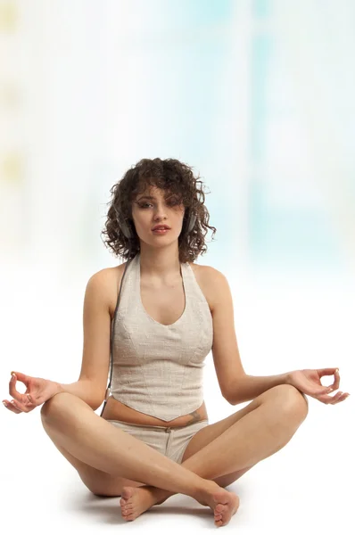 Curly beautiful woman meditating with music in Easy yoga Pose — Stock Photo, Image