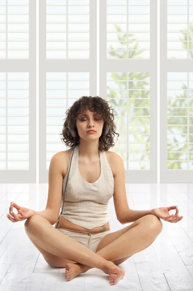 Curly mulher bonita meditando com música — Fotografia de Stock