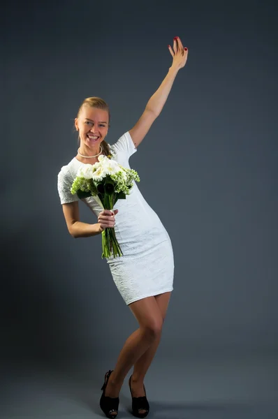 Жінка з букетом хризантем тримає руку вгору — стокове фото