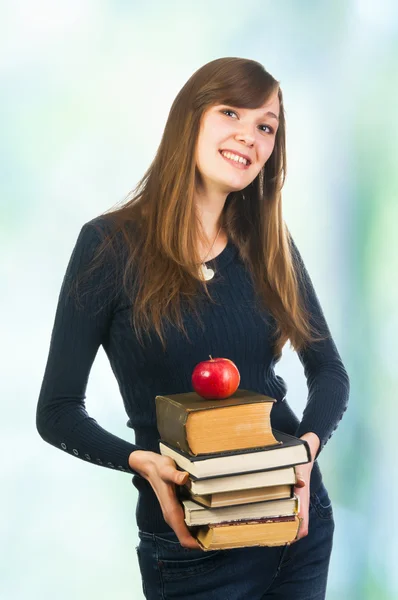 Kvinna anläggning böcker och apple — Stockfoto