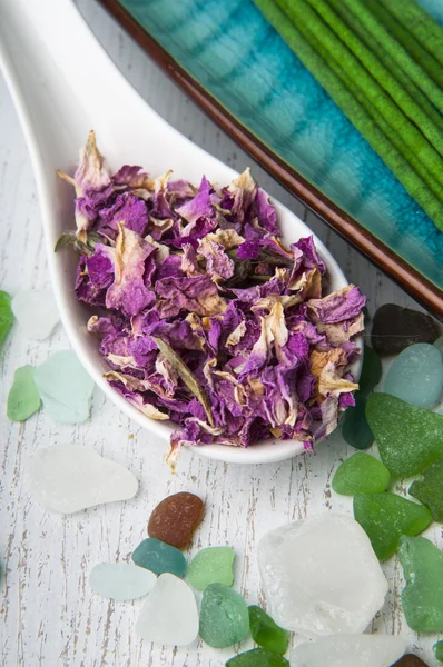 Spa rose petals in the spoon and aromatic sticks — Stock Photo, Image