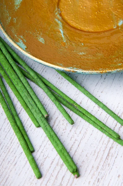 Золотая покрашенная тарелка и ароматические палочки — стоковое фото